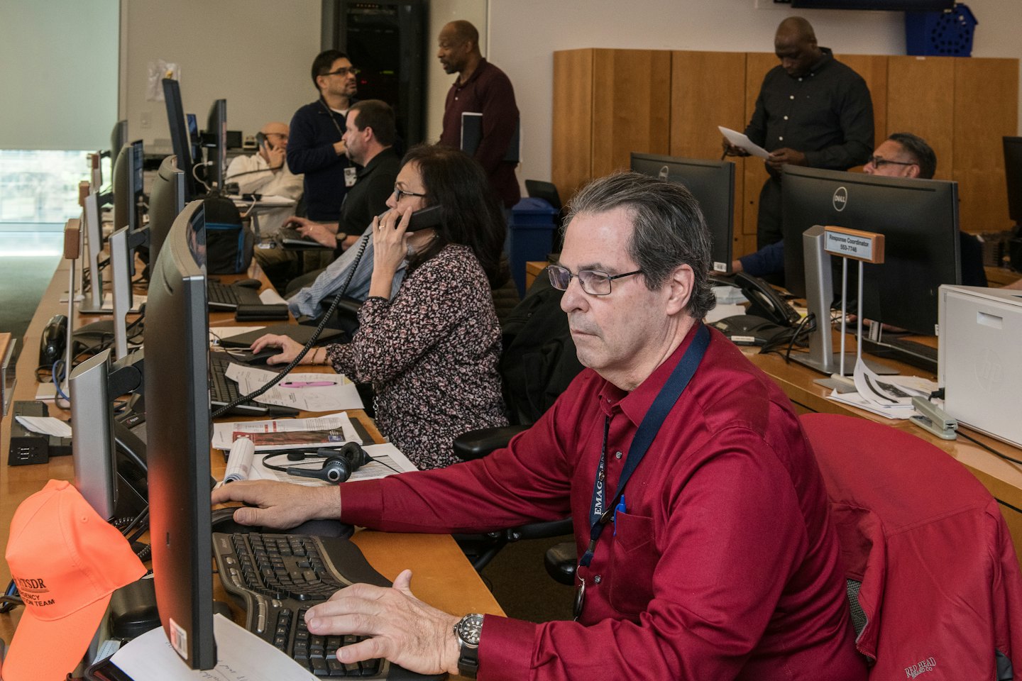 Vielfältiges Team arbeitet an Computern in einem belebten Büro.